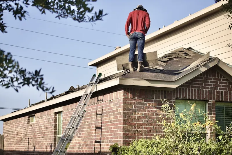 Professional roofer working on a residential roof in Kenland